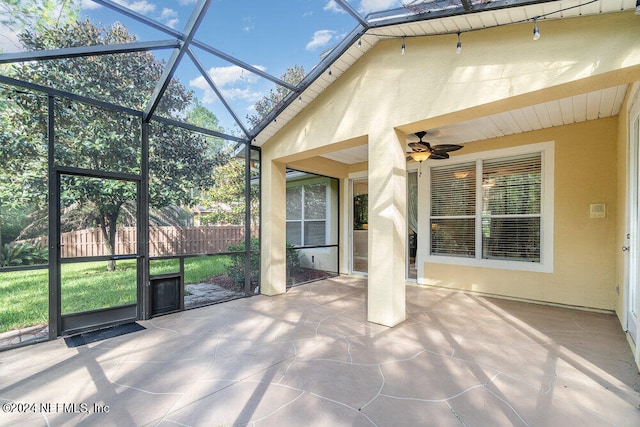 unfurnished sunroom featuring ceiling fan