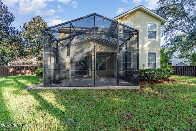 rear view of house with a lanai and a yard