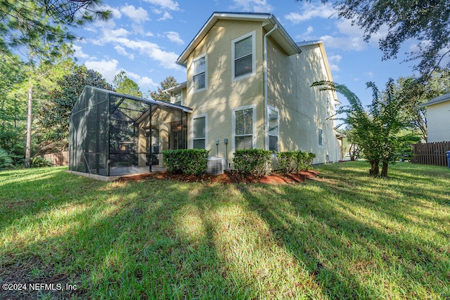 back of property featuring a lawn and a lanai