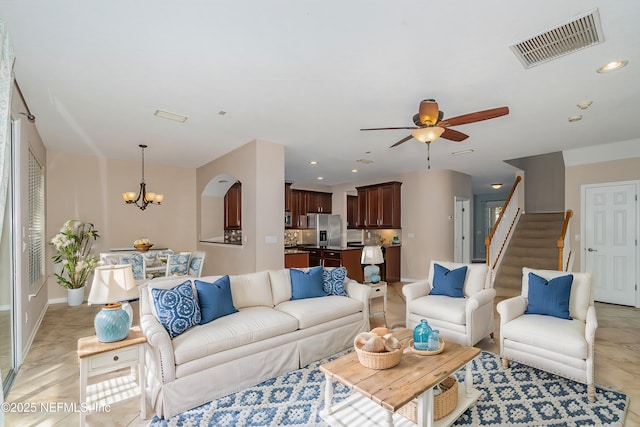 living room featuring ceiling fan with notable chandelier