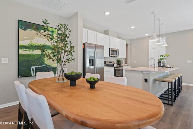 dining space with dark wood-type flooring and sink