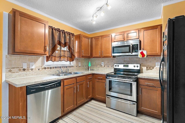 kitchen with appliances with stainless steel finishes, sink, and a textured ceiling