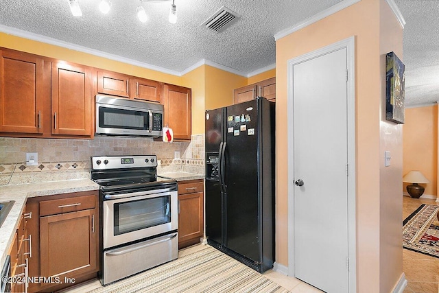 kitchen with light tile patterned flooring, stainless steel appliances, backsplash, and ornamental molding