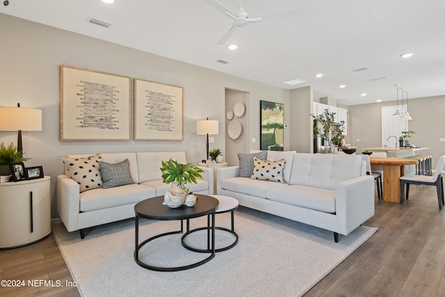 living room featuring hardwood / wood-style floors and ceiling fan