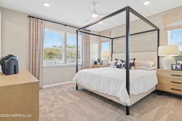 bedroom featuring multiple windows, ceiling fan, and light colored carpet