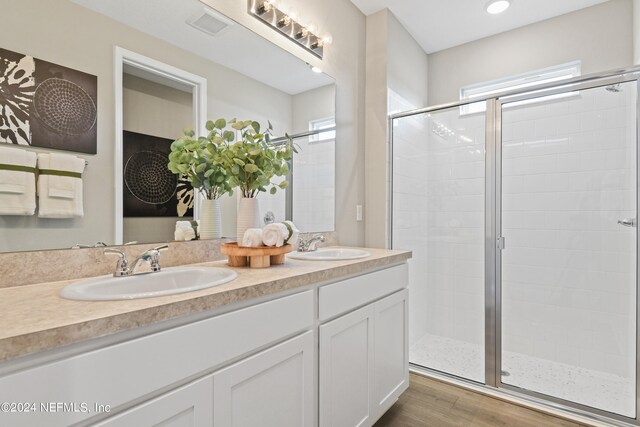 bathroom with a shower with door, vanity, and wood-type flooring