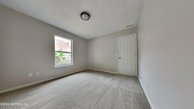 unfurnished room featuring carpet flooring and a textured ceiling