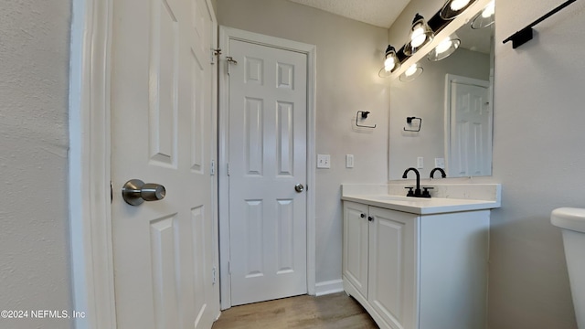 bathroom featuring vanity, toilet, and wood finished floors