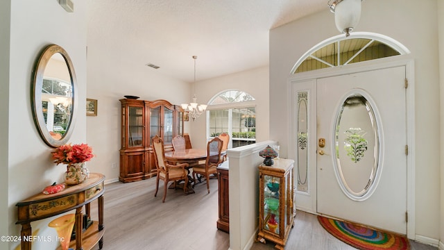 entrance foyer featuring light hardwood / wood-style floors and a notable chandelier