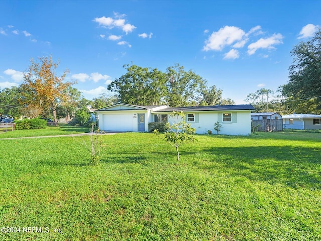 ranch-style home featuring a front lawn and a garage