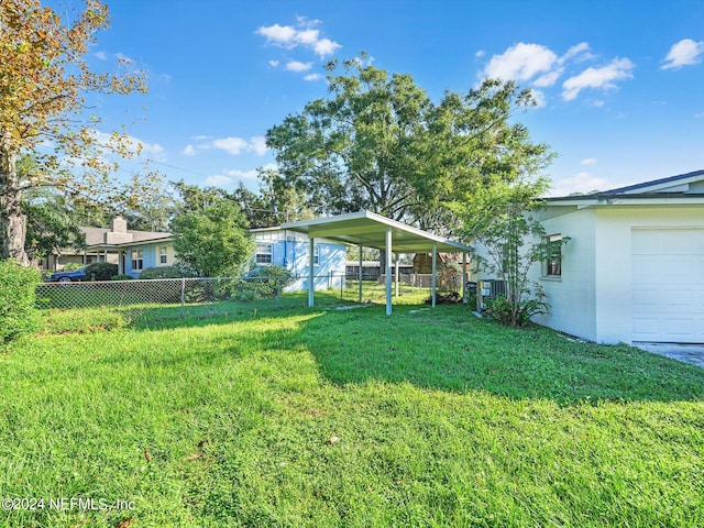 view of yard featuring a garage and a carport