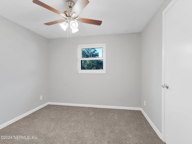 carpeted spare room featuring ceiling fan