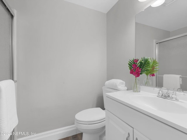 bathroom with toilet, vanity, wood-type flooring, and walk in shower