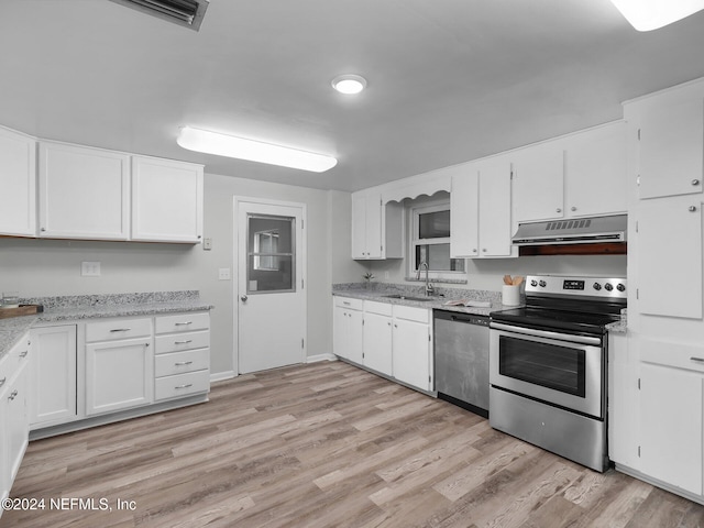 kitchen featuring stainless steel appliances, light stone counters, white cabinets, sink, and light hardwood / wood-style flooring