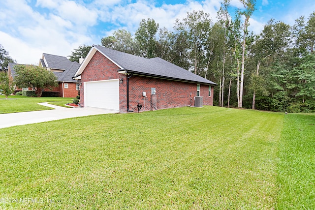 view of side of home featuring cooling unit, a yard, and a garage