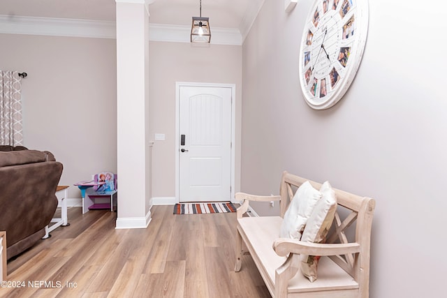 foyer with ornamental molding, decorative columns, and light hardwood / wood-style floors