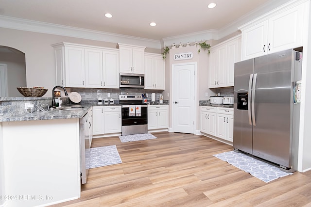 kitchen with appliances with stainless steel finishes, light hardwood / wood-style flooring, white cabinets, and sink