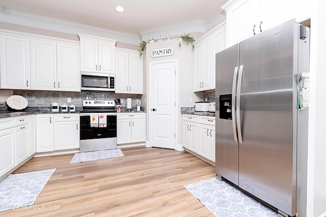 kitchen with appliances with stainless steel finishes, white cabinetry, and light hardwood / wood-style floors