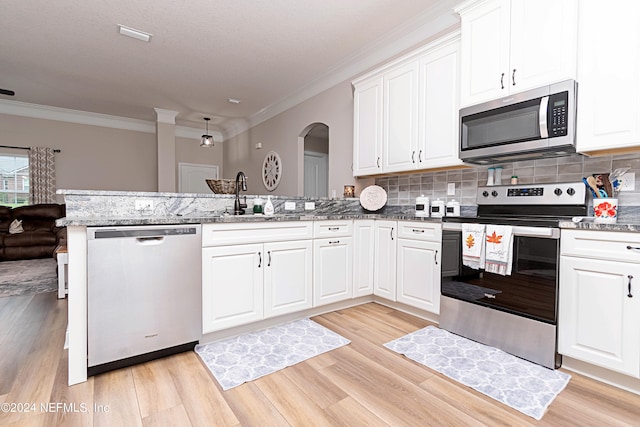 kitchen with appliances with stainless steel finishes, kitchen peninsula, sink, and light wood-type flooring