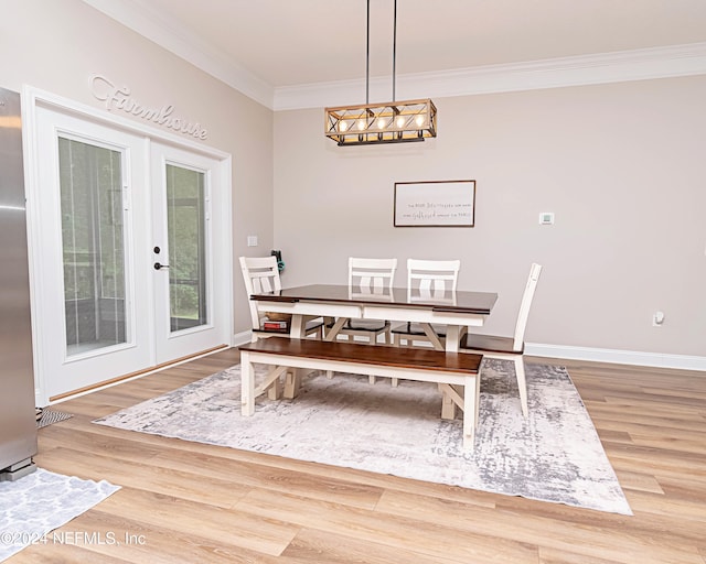 dining area with french doors, crown molding, and hardwood / wood-style flooring