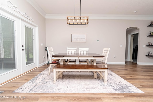 dining space with crown molding, wood-type flooring, and a chandelier