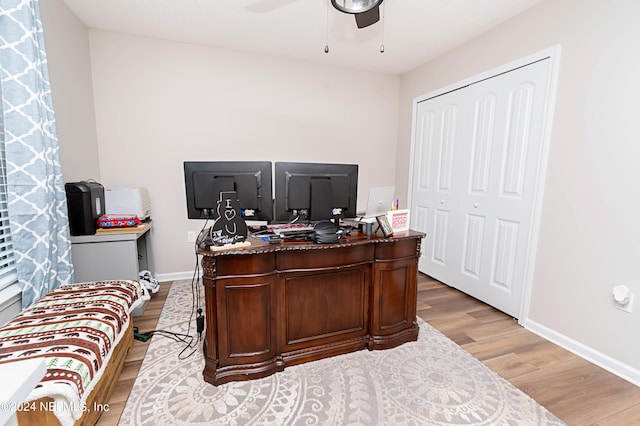 office with light hardwood / wood-style floors and ceiling fan