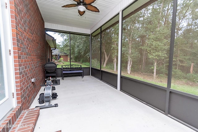 unfurnished sunroom with ceiling fan