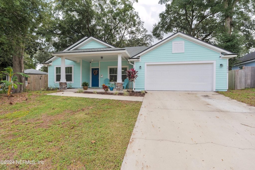 view of front facade with a garage, a porch, and a front lawn