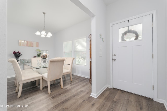 foyer entrance with a notable chandelier, a healthy amount of sunlight, and wood-type flooring