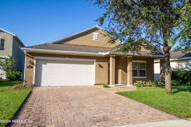 view of front of home with a front yard and a garage