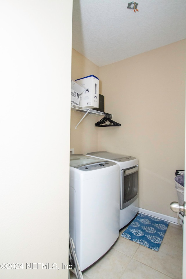 washroom featuring light tile patterned flooring and washer and dryer