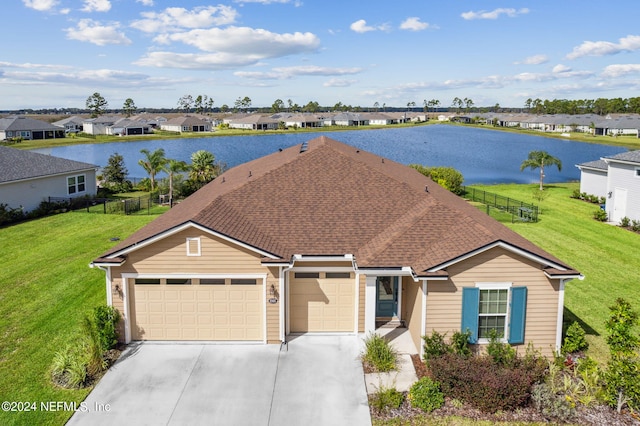 view of front of property featuring a residential view, a water view, concrete driveway, a front yard, and a garage