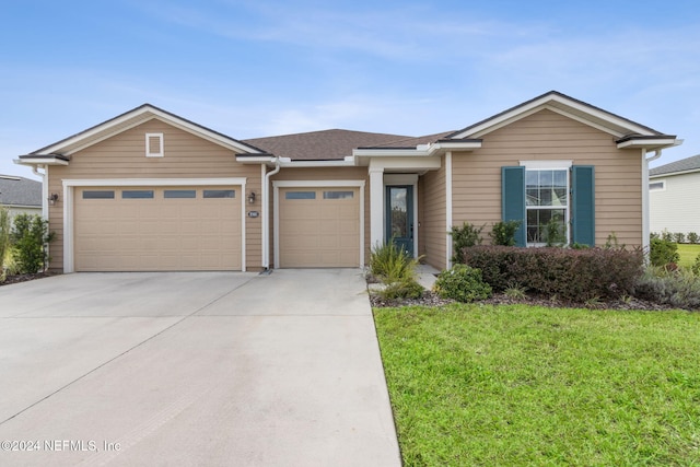 ranch-style home with a garage, driveway, a shingled roof, and a front lawn