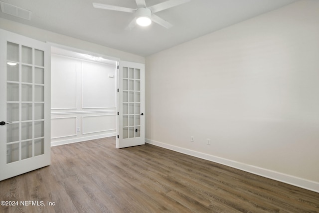 spare room with french doors, visible vents, baseboards, wood finished floors, and ceiling fan