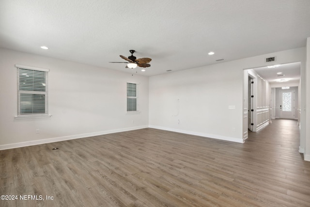 empty room with a ceiling fan, wood finished floors, visible vents, and recessed lighting