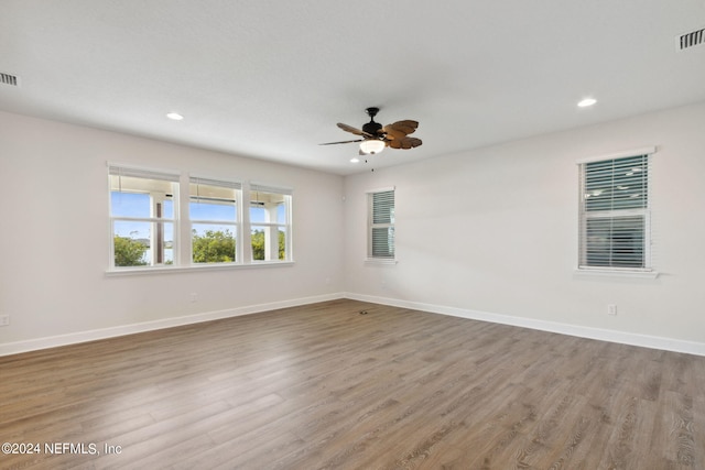 empty room featuring recessed lighting, wood finished floors, a ceiling fan, and baseboards
