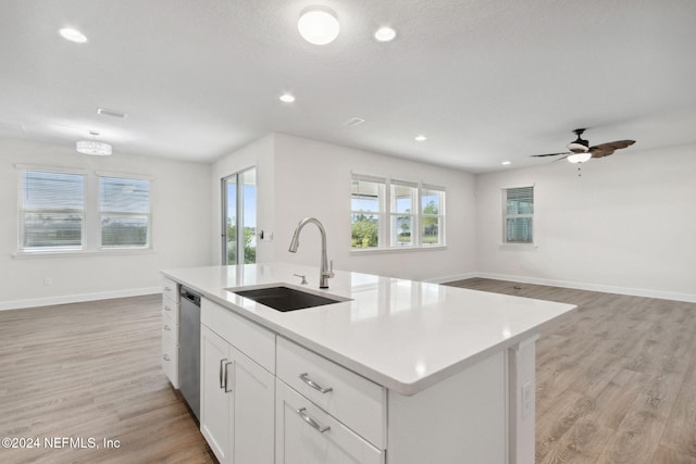 kitchen featuring sink, light hardwood / wood-style floors, white cabinetry, a center island with sink, and dishwasher