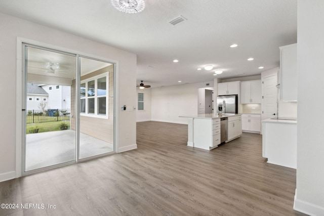kitchen with baseboards, visible vents, appliances with stainless steel finishes, and open floor plan