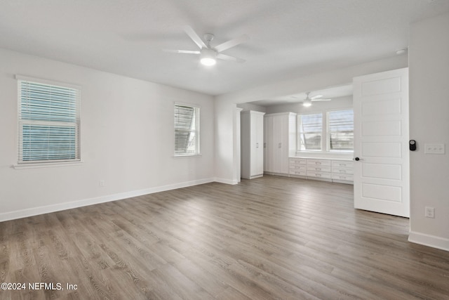 spare room with baseboards, a ceiling fan, and wood finished floors