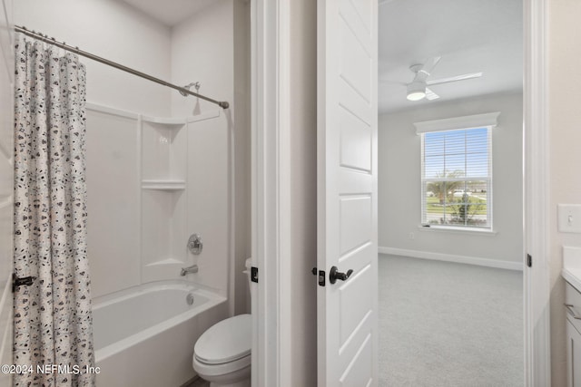 bathroom featuring toilet, vanity, a ceiling fan, shower / bath combo with shower curtain, and baseboards