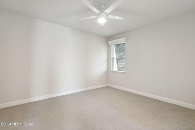 carpeted empty room with ceiling fan and baseboards