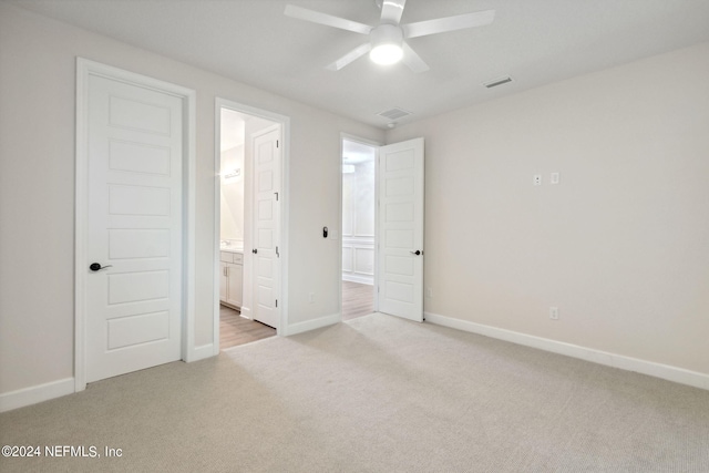 unfurnished bedroom featuring ensuite bathroom, ceiling fan, and light carpet