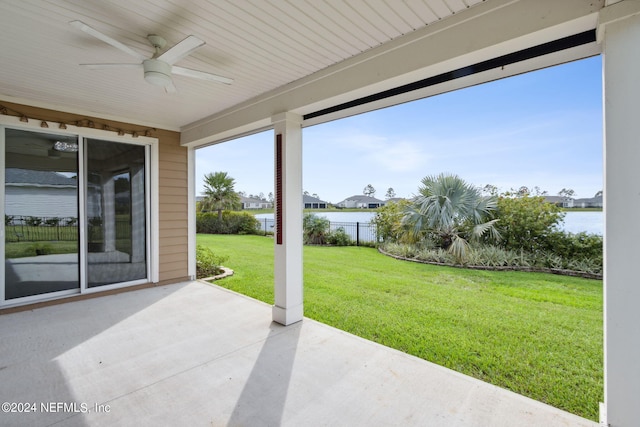 view of patio / terrace featuring fence, a water view, and a ceiling fan