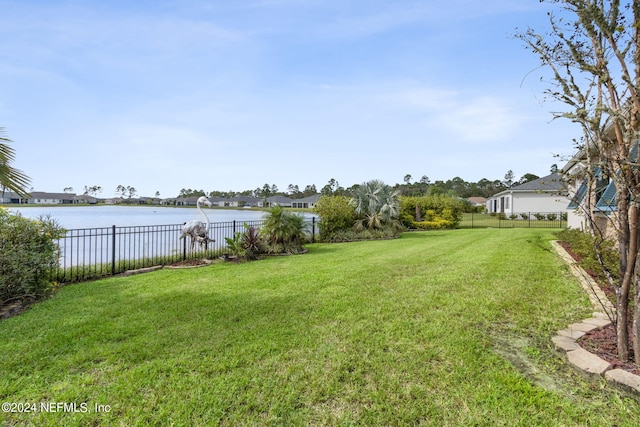 view of yard featuring fence and a water view