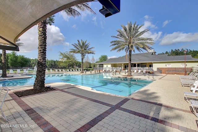 community pool with fence and a patio