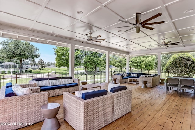 wooden terrace with fence, ceiling fan, and an outdoor hangout area