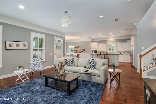 living room with a notable chandelier, crown molding, and dark hardwood / wood-style flooring