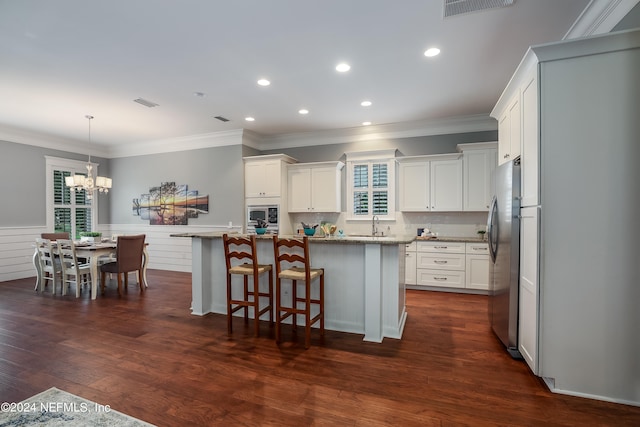 kitchen featuring dark hardwood / wood-style floors, a kitchen breakfast bar, a center island, and stainless steel appliances