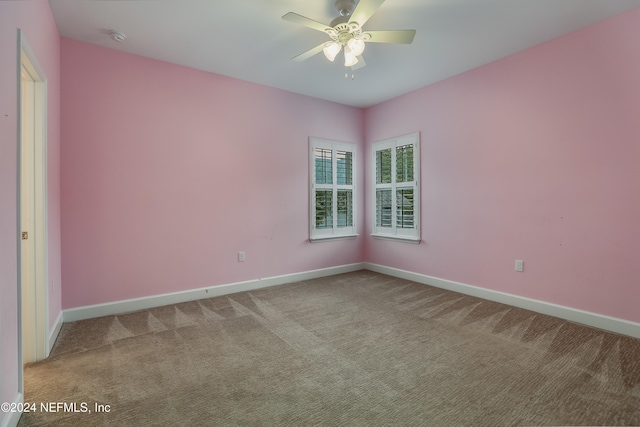 carpeted spare room featuring ceiling fan