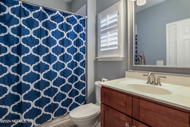 bathroom featuring curtained shower, tile patterned floors, vanity, and toilet